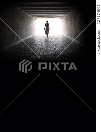 A woman emerges from a tunnel into the light 127174661