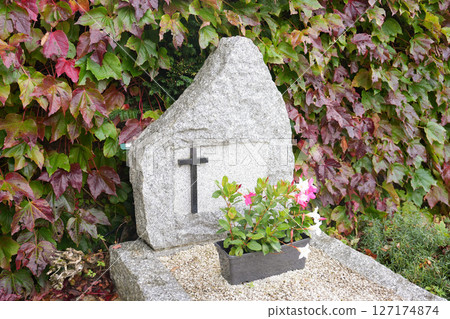 Cross on a stone marble slab on a grave in a cemetery 127174874
