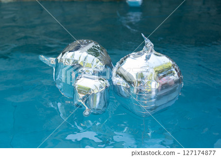 Silver balloons float in pools as birthday party decorations 127174877