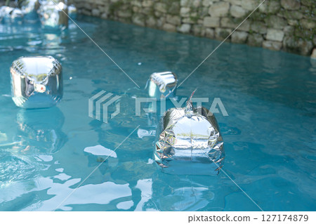 Silver balloons float in pools as birthday party decorations 127174879