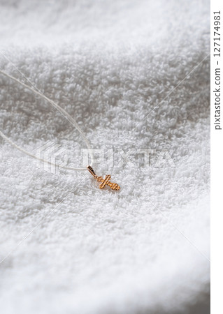 Golden Orthodox Cross Pendant on White Towel Background Symbolizing Faith and Purity 127174981