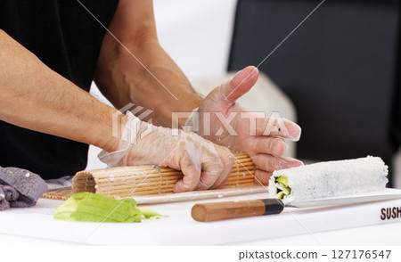 Chef Preparing Sushi Roll Using Bamboo Mat on a Clean Work Surface Chef Preparing Sushi Roll Using Bamboo Mat on a Clean Work Surface 127176547