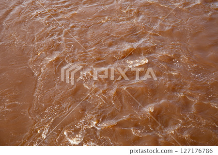 Turbulent Brown River Water with Reflections and Flow Patterns in Natural Daylight Turbulent Brown River Water with Reflections and Flow Patterns in Natural Daylight 127176786