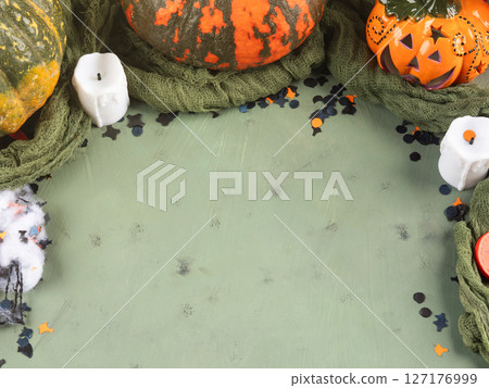 Halloween green frame background flatlay with colorful pumpkins and confetti 127176999