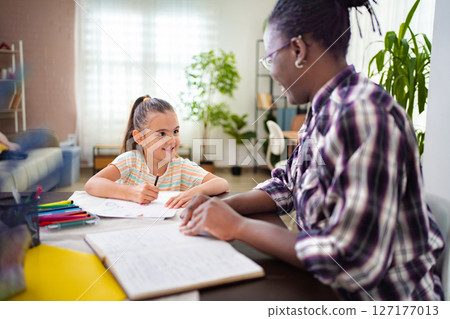 Inspiring moments between a tutor and student in a bright study space Inspiring moments between a tutor and student in a bright study space 127177013