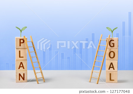 Wooden cubes with the words plan and goal, young green seedling and wooden ladders are a symbol of success, business progress, strategic development of a company, startup. Business concept Wooden cubes with the words plan and goal, young green seedling and wooden ladders are a symbol of success, business progress, strategic development of a company, startup. Business concept 127177048