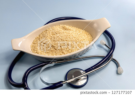 Sesame seeds in a white bowl and stethoscope 127177107