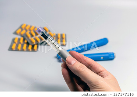 Hand holding Ozempic Insulin injection pen for diabetics and weight loss Hand holding Ozempic Insulin injection pen for diabetics and weight loss 127177116