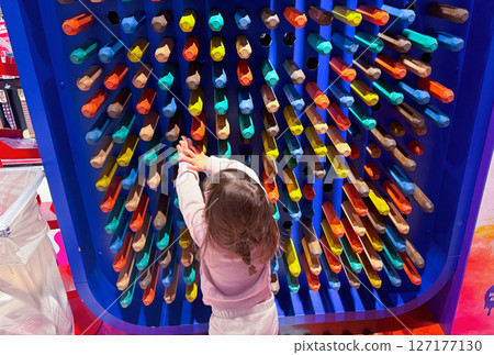 Background with large wooden colored crayon wall and a little girl with brown hair Background with large wooden colored crayon wall and a little girl with brown hair 127177130