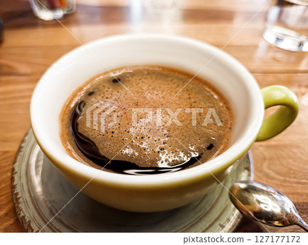 Green Coffee Cup on Wooden Cafe Table Green Coffee Cup on Wooden Cafe Table 127177172