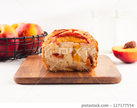 Peach cake loaf on wooden cutting board on white backgroud Peach cake loaf on wooden cutting board on white backgroud 127177554