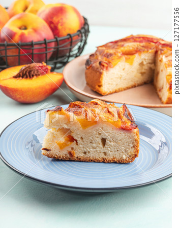 Piece of nectarine peach cake on turquoise table Piece of nectarine peach cake on turquoise table 127177556