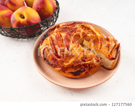 Vegan nectarine peach cake on white table, summer fruit pie 127177560