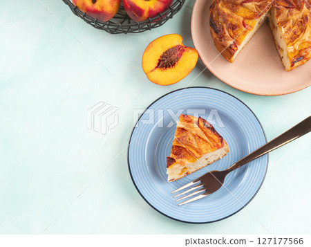 Piece of nectarine peach cake on turquoise table 127177566