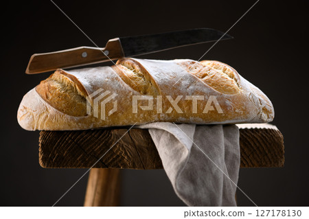 Crusty sourdough baguette bread with cracked crust 127178130