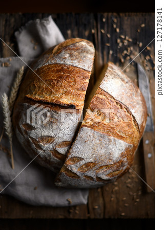Rustic sourdough bread cutting in half 127178141