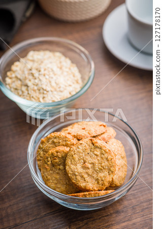 Sweet oatmeal cookies in bowl on wooden table. Sweet oatmeal cookies in bowl on wooden table. 127178170