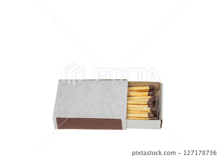 Close-up photograph of a slightly open matchbox, without identifying inscriptions, with yellow matches and brown sulfur heads arranged in a row, isolated on white background. Blank for art Close-up photograph of a slightly open matchbox, without identifying inscriptions, with yellow matches and brown sulfur heads arranged in a row, isolated on white background. Blank for art 127178736