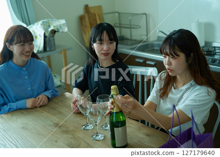 Women drinking wine at a home party Women drinking wine at a home party 127179640