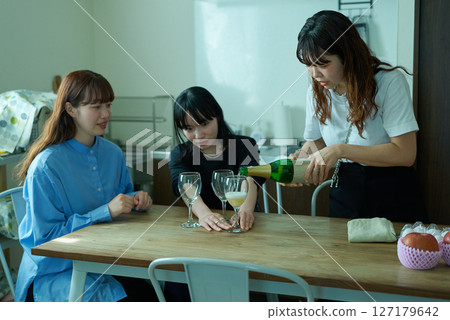 Women drinking wine at a home party Women drinking wine at a home party 127179642