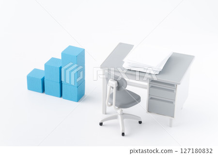 A miniature office desk with documents and blue building blocks arranged in a staircase A miniature office desk with documents and blue building blocks arranged in a staircase 127180832