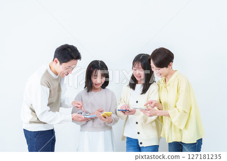 Parents and children showing and using smartphones on white background 127181235