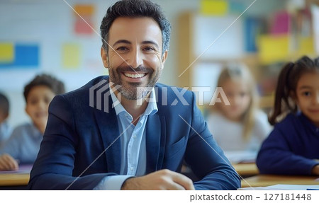 Confident Male Teacher Smiling in Classroom 127181448