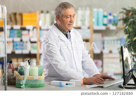 Pharmacist processing supply orders through pharmacy system Pharmacist processing supply orders through pharmacy system 127182880