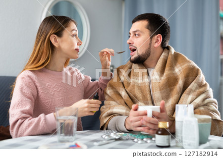 Sick man sitting with wife at home 127182914