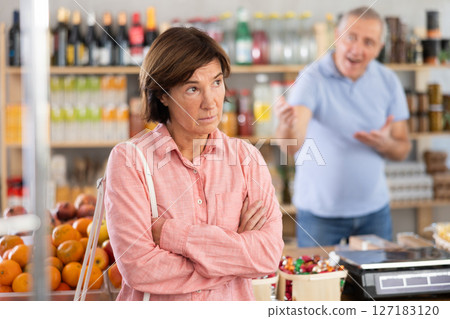 Senior husband stands behind pensioner wife and yells at companion Senior husband stands behind pensioner wife and yells at companion 127183120