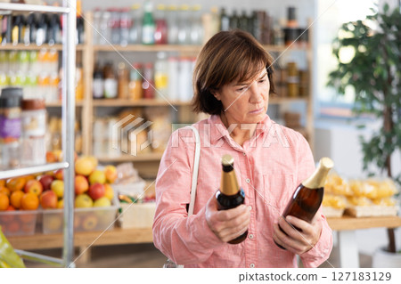 Mature woman choosing beer in grocery store 127183129