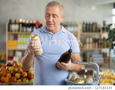 Mature man is choosing beer in grocery store 127183135