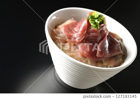 Two-tone bowl of red tuna and medium fatty tuna photographed against a black background Two-tone bowl of red tuna and medium fatty tuna photographed against a black background 127183145