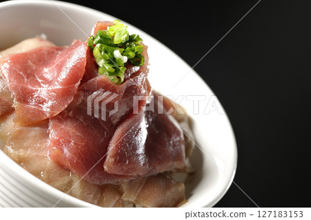Two-tone bowl of red tuna and medium fatty tuna photographed against a black background Two-tone bowl of red tuna and medium fatty tuna photographed against a black background 127183153