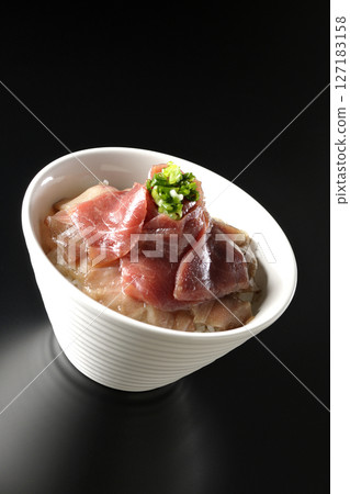 Two-tone bowl of red tuna and medium fatty tuna photographed against a black background Two-tone bowl of red tuna and medium fatty tuna photographed against a black background 127183158