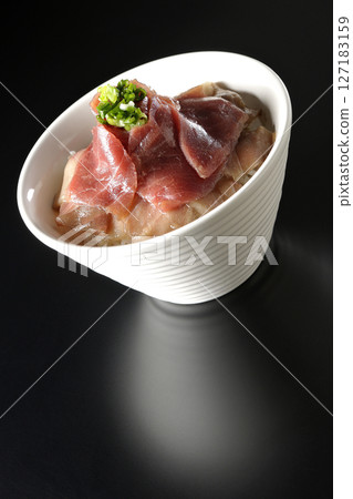 Two-tone bowl of red tuna and medium fatty tuna photographed against a black background Two-tone bowl of red tuna and medium fatty tuna photographed against a black background 127183159