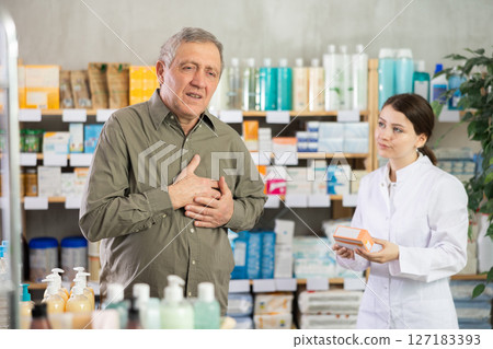 Elderly man complains to a pharmacist about pain in heart area Elderly man complains to a pharmacist about pain in heart area 127183393