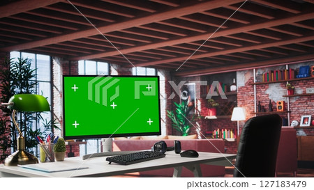Luxurious apartment workspace with chroma key screen on a clean empty desk. Spacious interior features wood and glass elements, creating a refined and cozy ambiance with artistic flair. 127183479