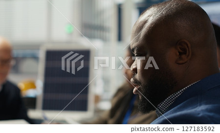 Photovoltaics plant engineering team works on breakthroughs in durability and performance in office. Teamworking research and development coworkers testing materials for next generation solar panels 127183592
