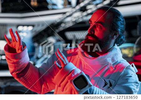 Scared astronaut in spaceship raises hand defensively during alien attack triggering onboard alert. Afraid orbital station crew member reacts to extraterrestrial form disturbance 127183650