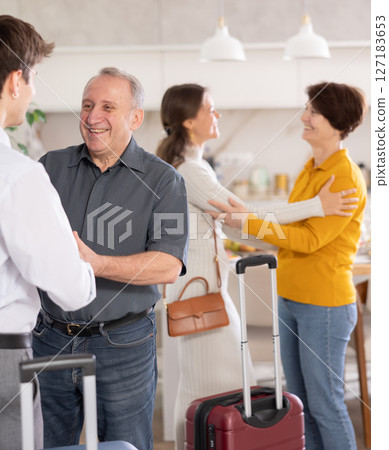 Parents joyfully welcome their adult children who have come to visit from far away 127183653