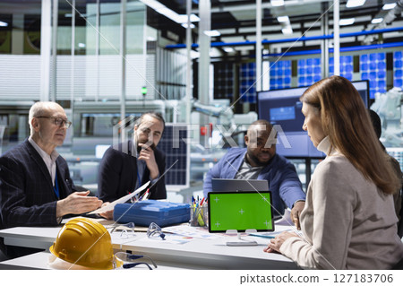 Industrial plant company management executive presents operational insights found during research and development and business strategies to investors using green screen tablet 127183706