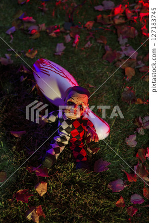 Halloween Prop Setup Featuring Clown Doll and Blood-Stained Weapon 127183745