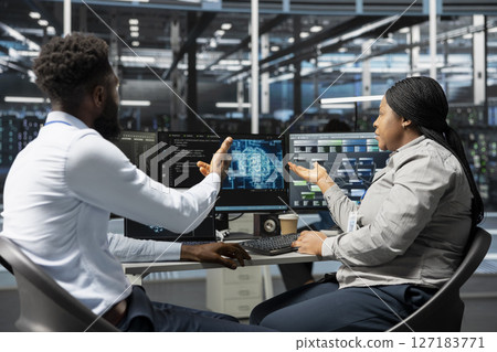 Server room software developers working together using artificial intelligence to reduce downtime. Workplace coworkers design and implement AI driven solutions for data center equipment 127183771
