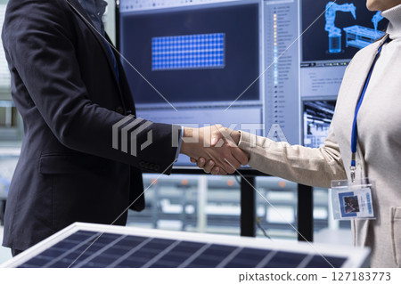 Manager shaking hands with investor, securing funding after solar panels presentation, closing deal. Close up of businesspeople doing handshake in industrial plant, agreeing terms during pitch meeting 127183773