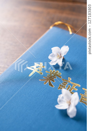 Diploma and cherry blossom petals 127183803