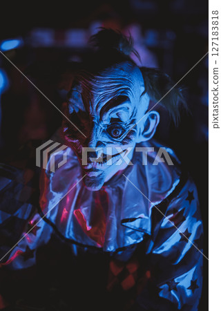 Terrifying Halloween Clown with Glowing Eyes in Haunted House 127183818