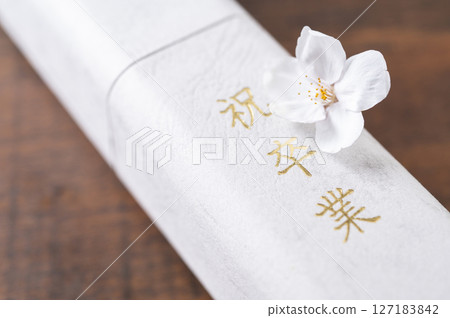 Diploma and cherry blossom petals Diploma and cherry blossom petals 127183842