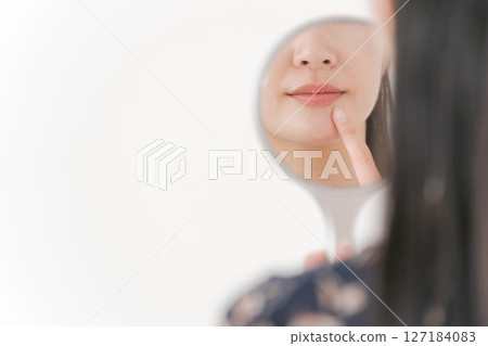 Female face parts reflected in the mirror 127184083