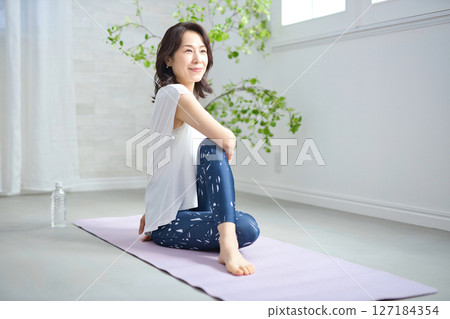 一位 50 多歲的女性穿著瑜伽服做瑜伽 127184354